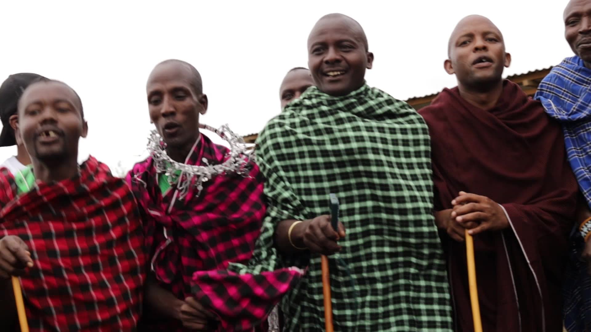 Maasai participants performing a jumping dance outdoors in Tanzania; reference footage, not OLORIO hosts